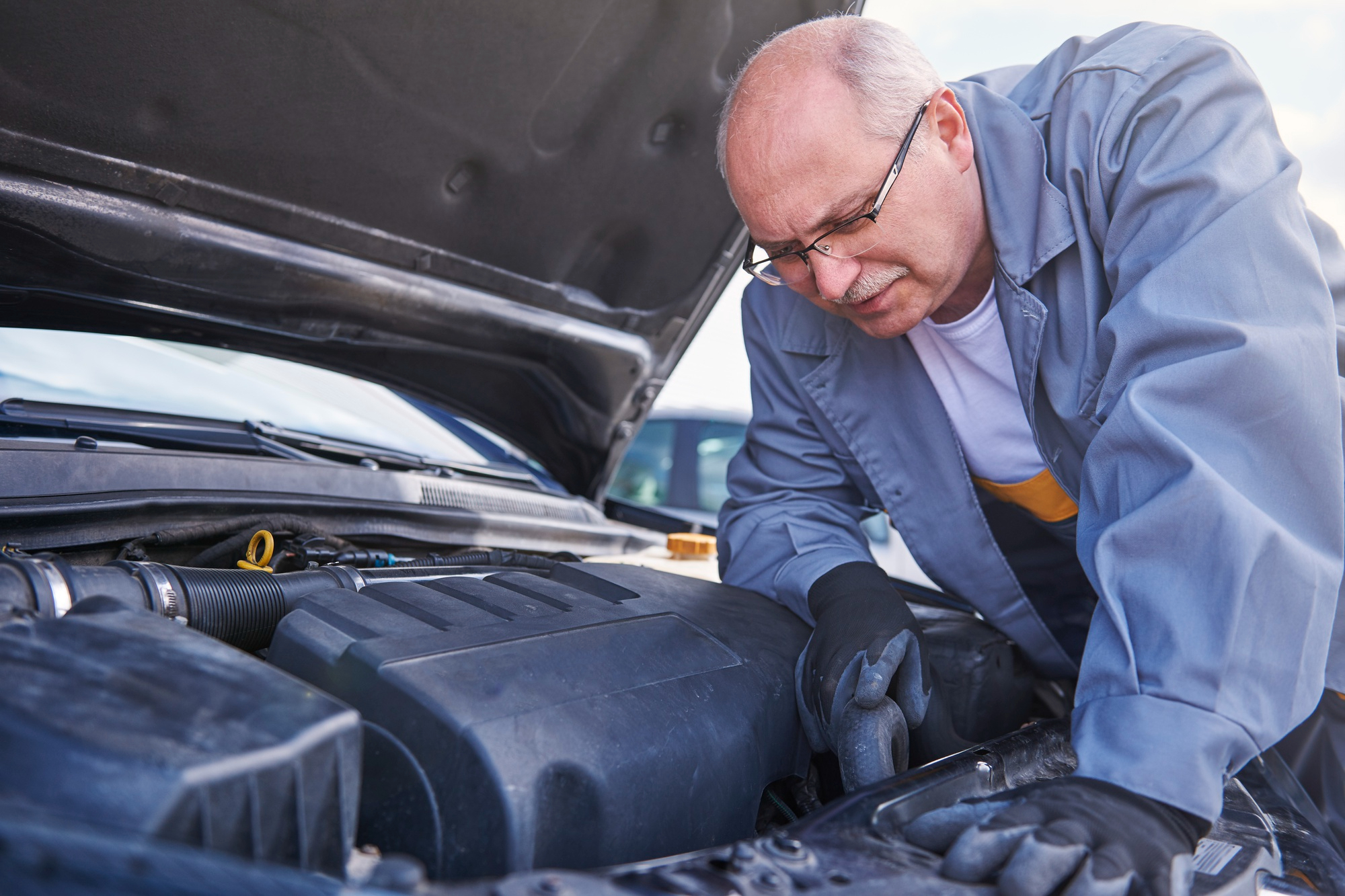 Expert mechanic inspecting engine for leaks